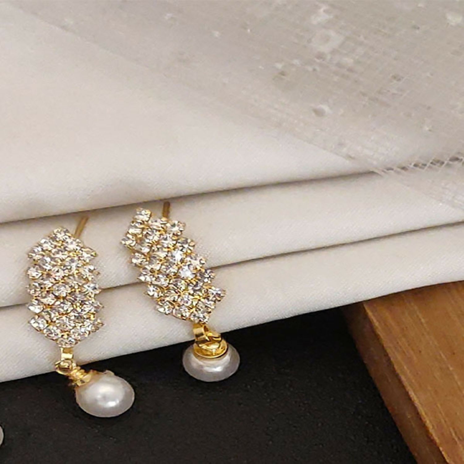 Multiple pairs of classic gold plated jhumka earrings displayed