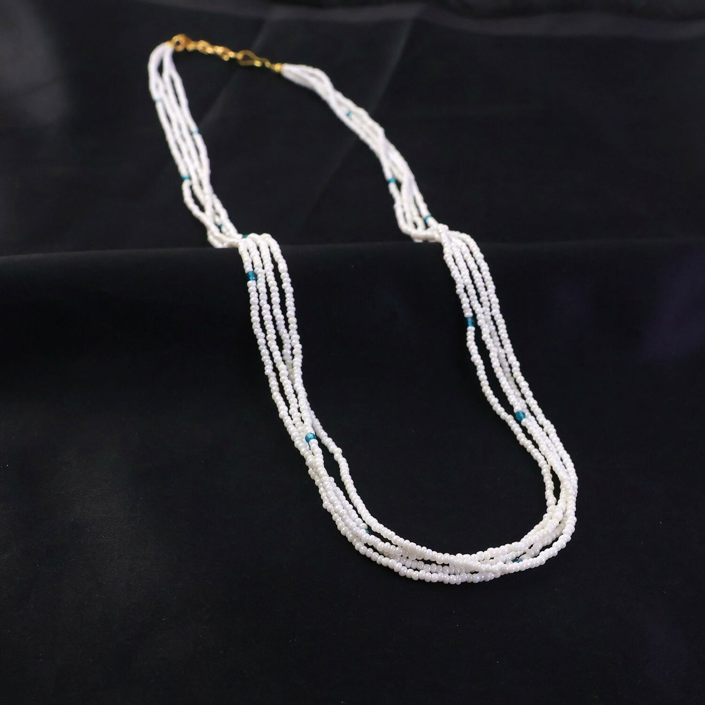 Close-up of pearl beads and blue accents on mala necklace