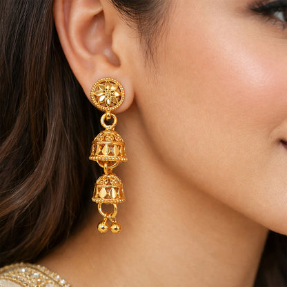 Close-up of intricate floral design in gold jhumka earrings