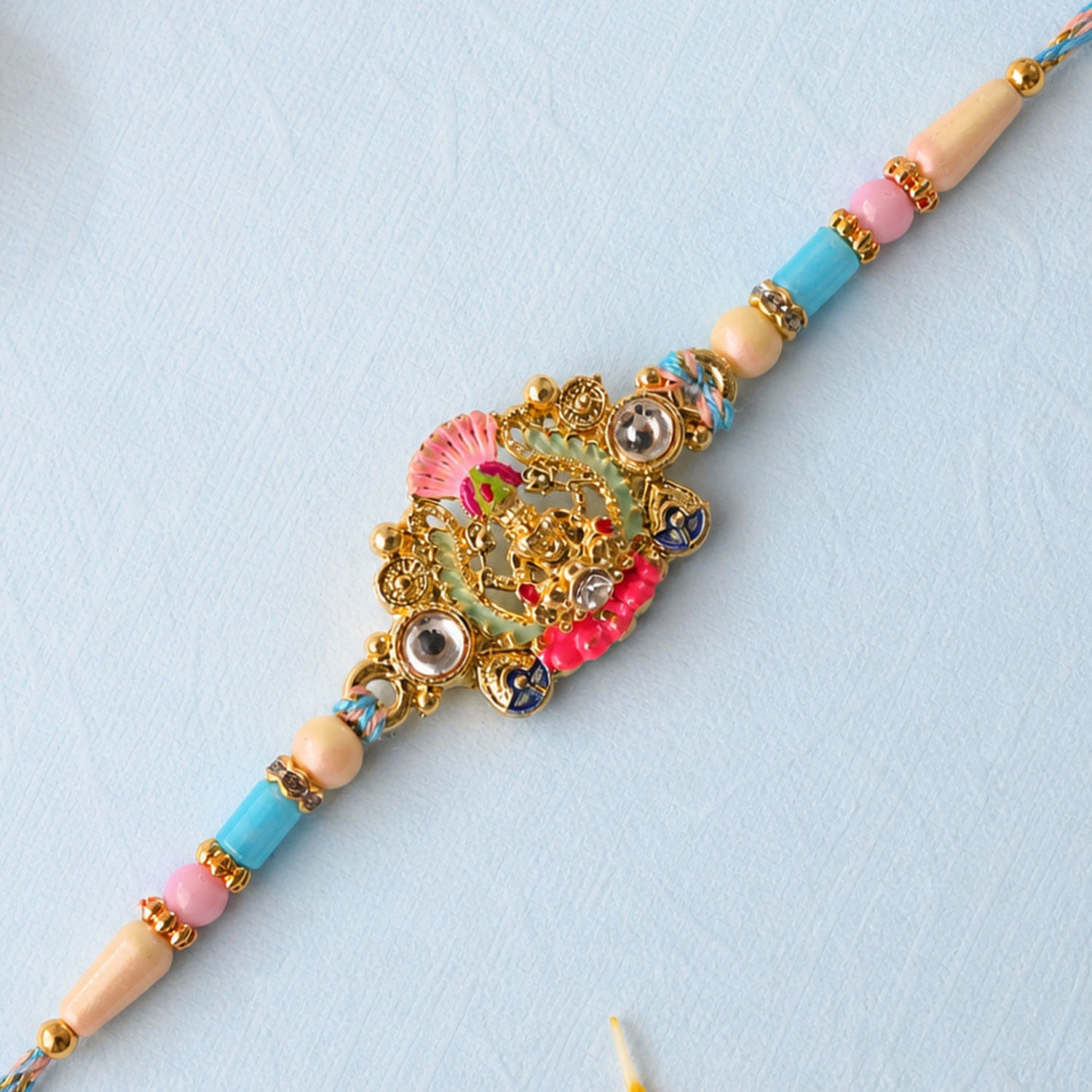 Gold Peacock Kundan Pendant Rakhi with Pastel Beads