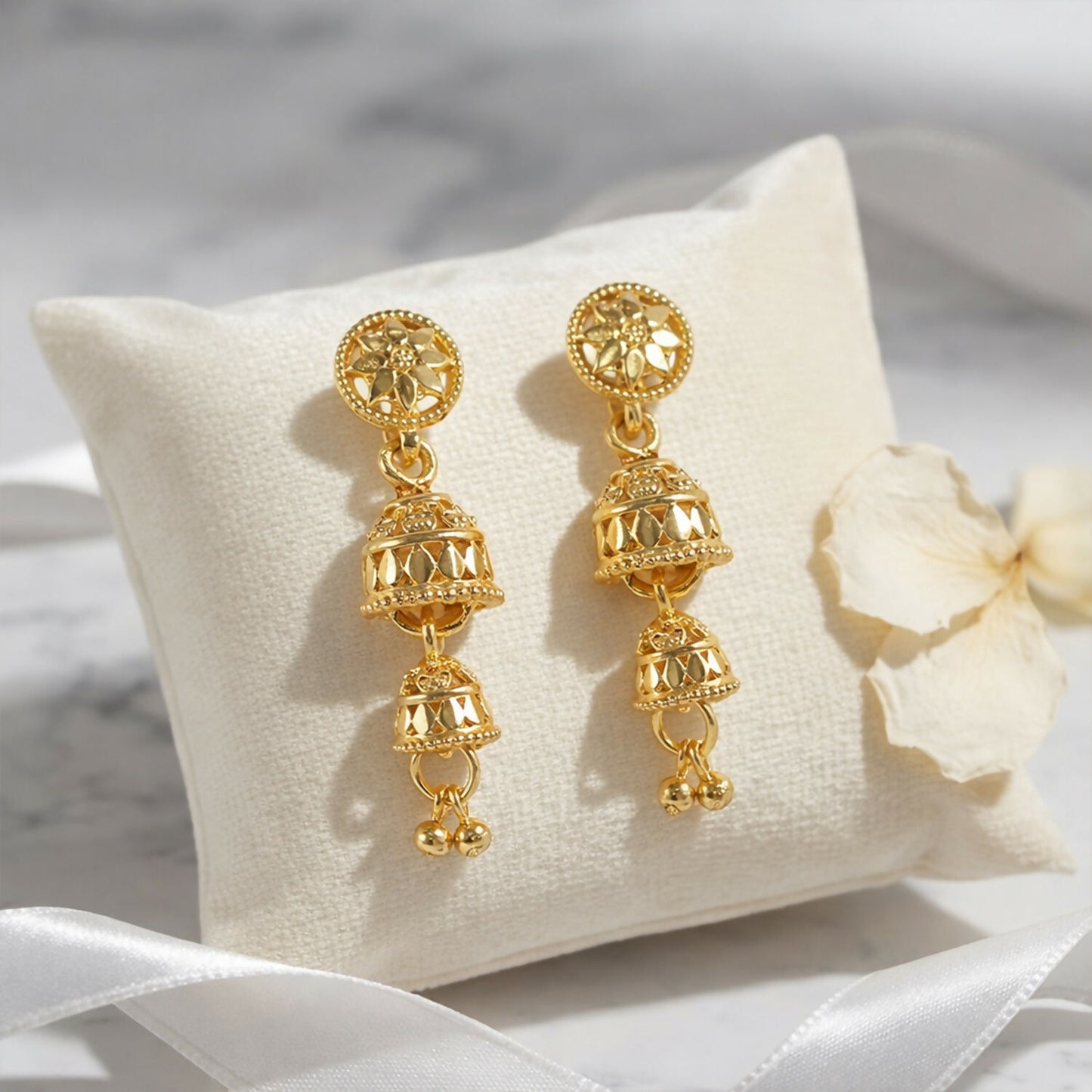 Side view of ethnic gold jhumka earrings with hanging beads