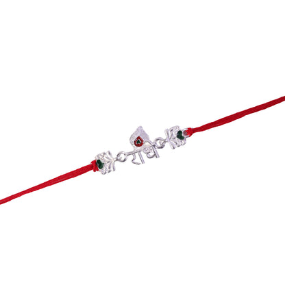 Silver Radhe Morpich Text Rakhi with Green Stones and Red Thread