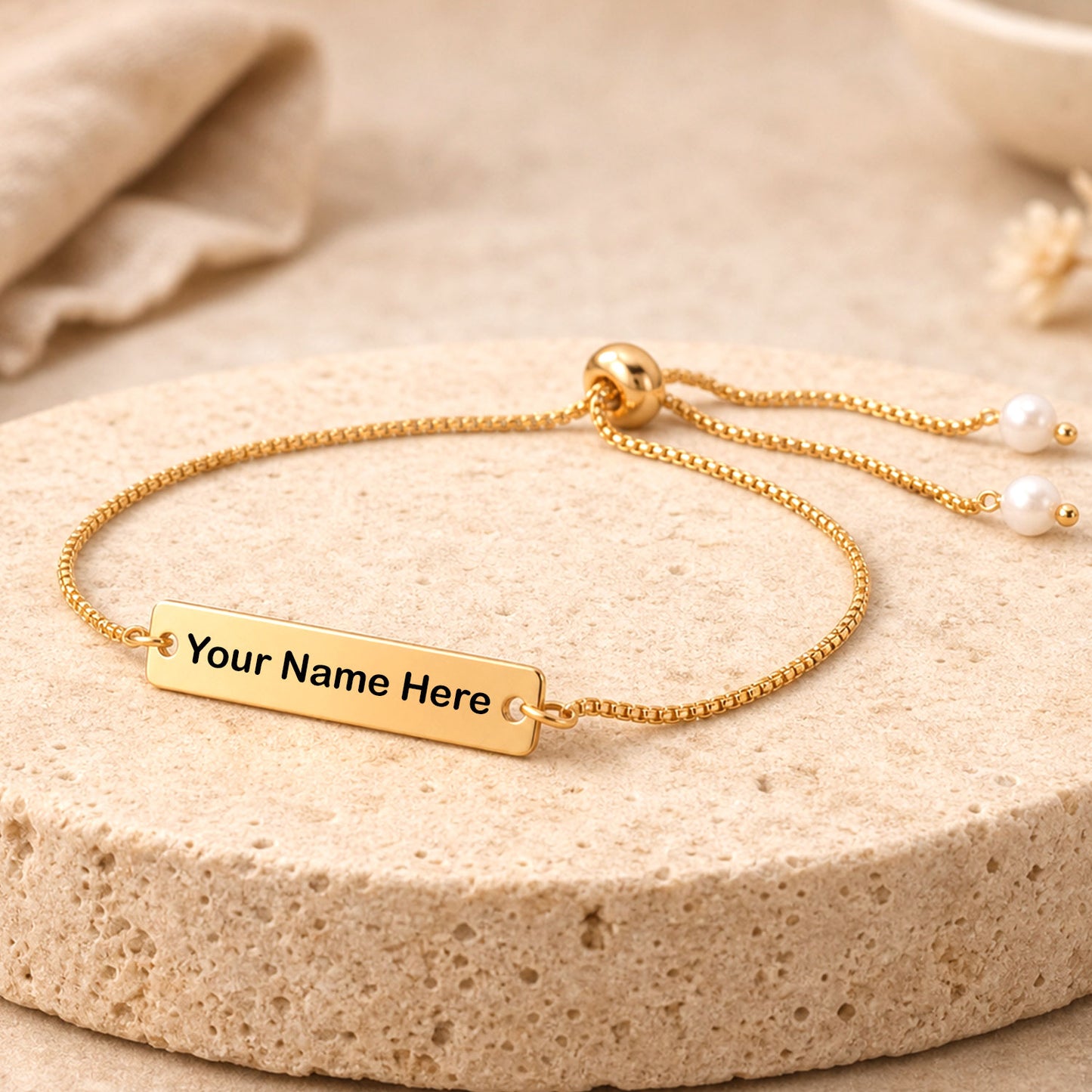 Custom name bracelet with adjustable gold tone chain and pearl beads displayed.