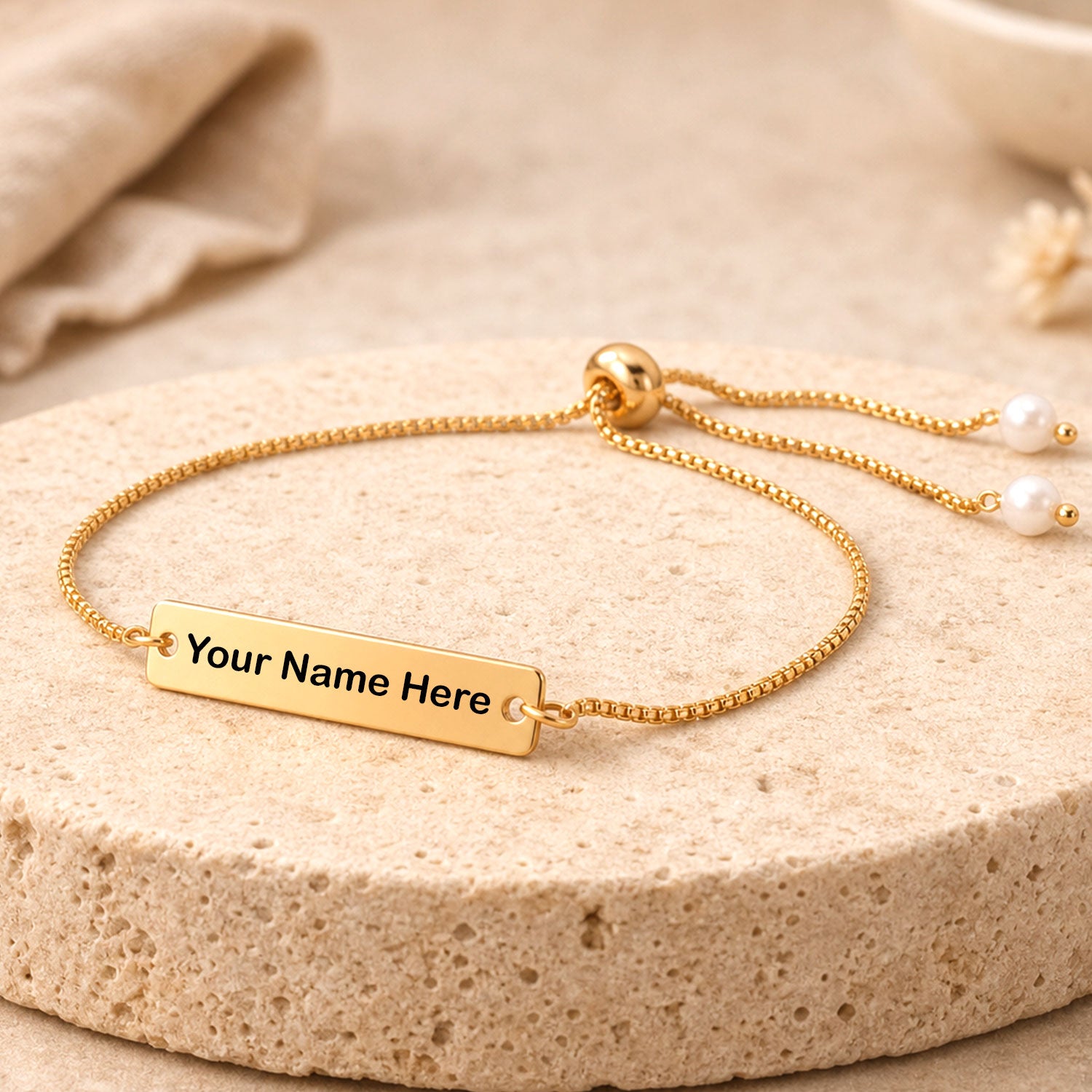 Custom name bracelet with adjustable gold tone chain and pearl beads displayed.