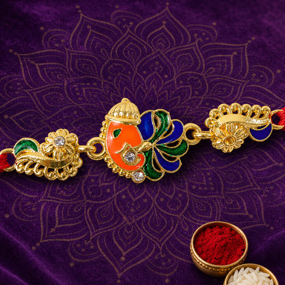 Gold-Toned Lord Ganesha Rakhi with Peacock Feather Enamel, Crystal Accents & Designer Red Thread