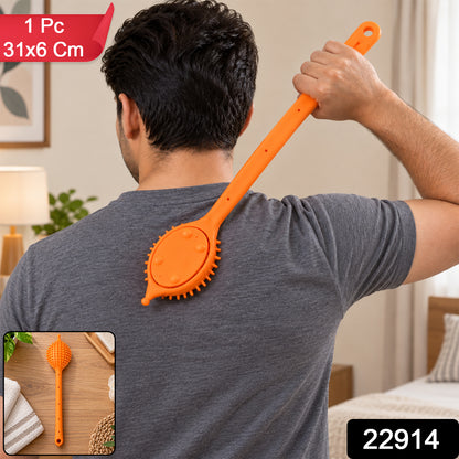A person uses an orange silicone back scrubber on their back, with an inset showing the scrubber on a wooden surface.
