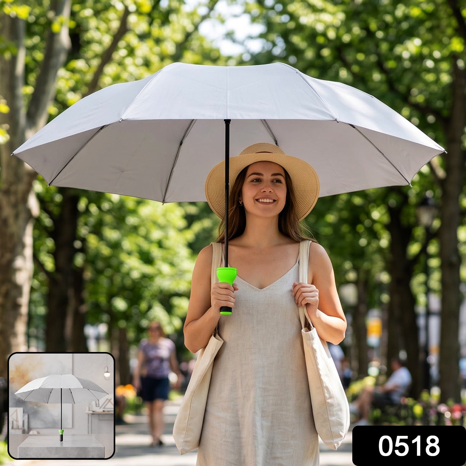 Woman holding a large grey umbrella with a bright green handle while walking in a park, with '0518' watermark.