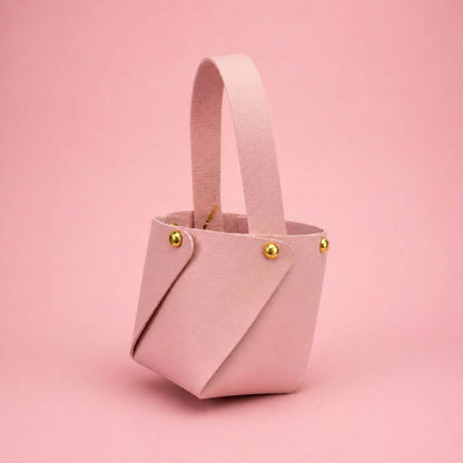 Top view of pink mini bucket handbag highlighting sturdy handle and studs