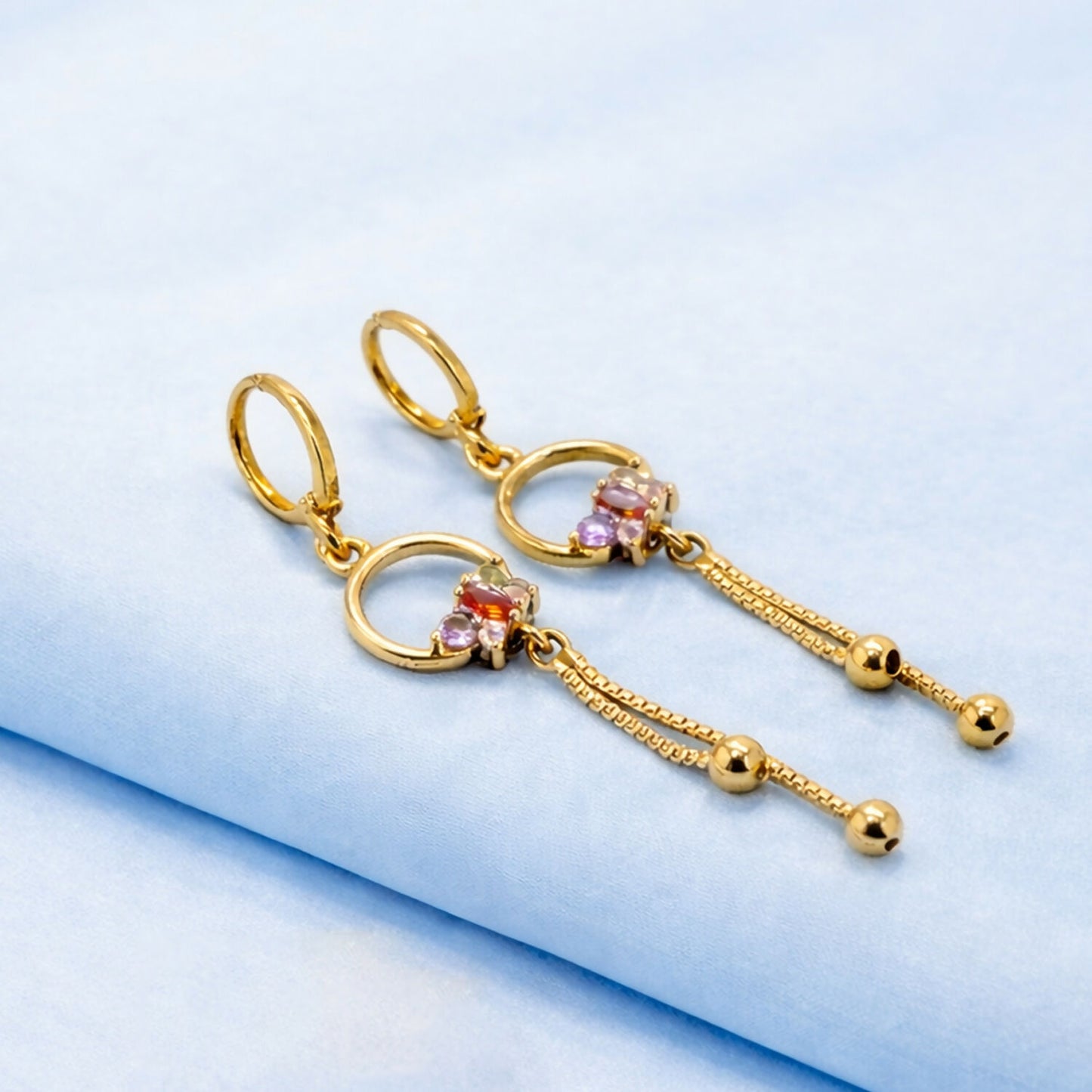 Pair of gold finish circle drop earrings with vibrant multicolor stone accents and chain tassels