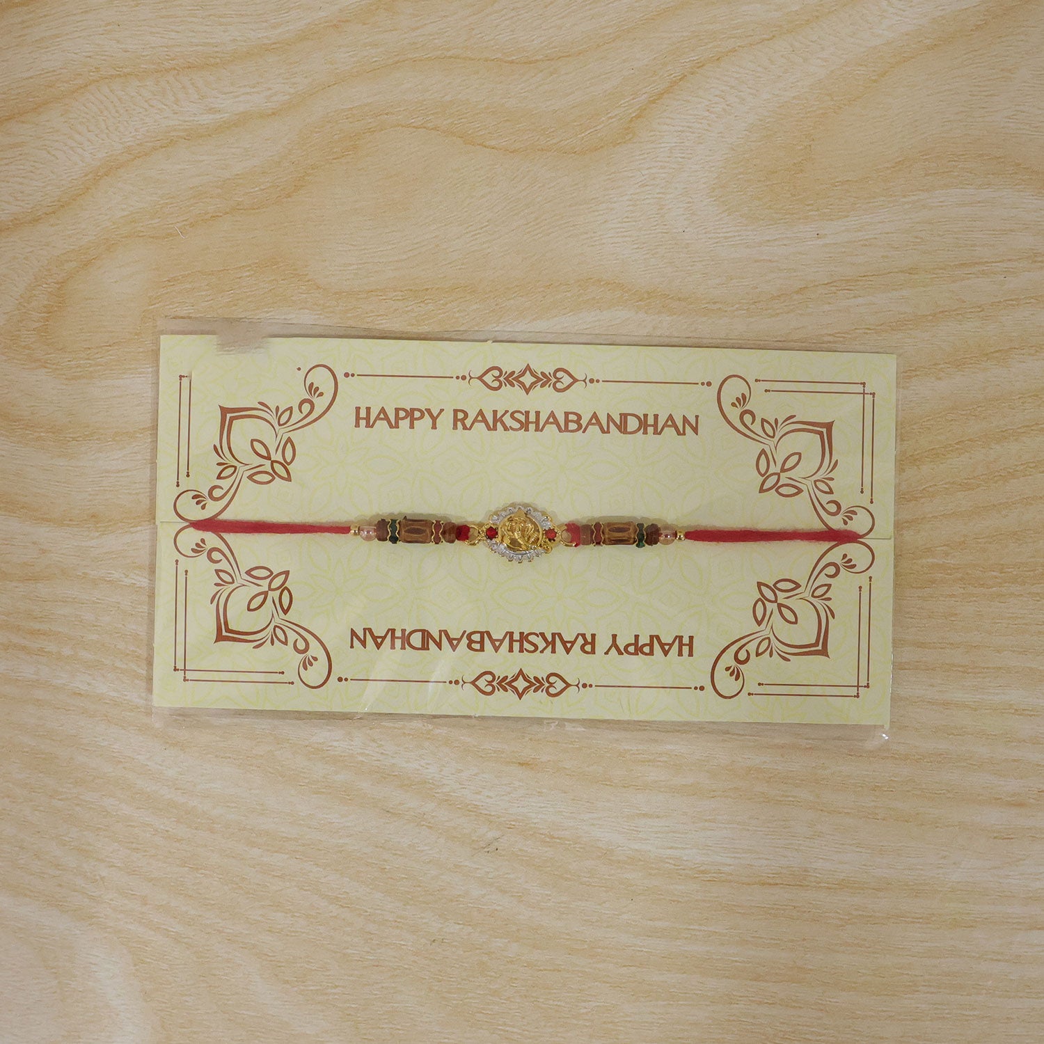 Ganesha Silver Ring Devotional Rakhi with Circular Centre and Red Green Beads