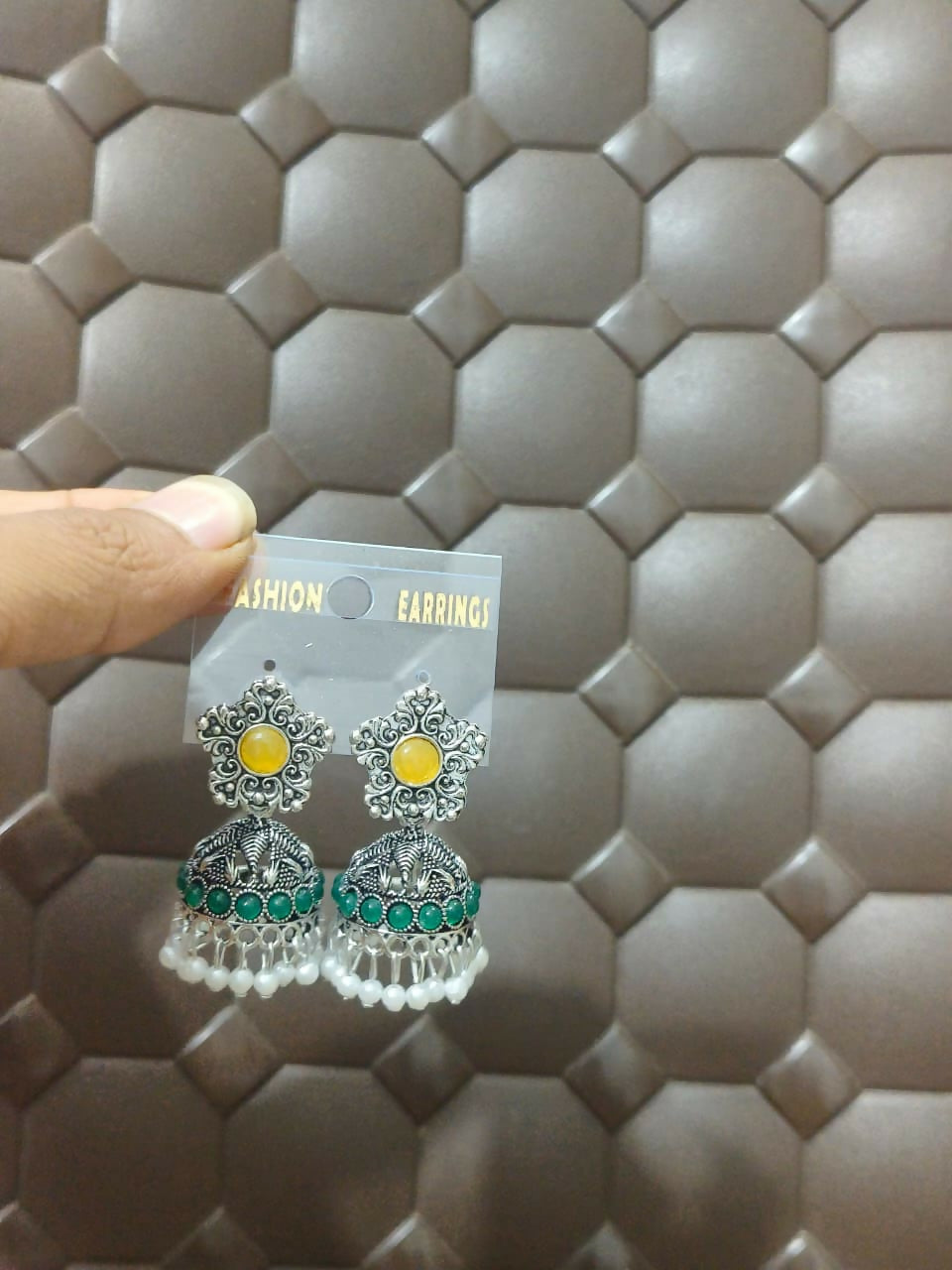 Model wearing oxidised silver jhumka earrings with yellow stones and pearl drops
