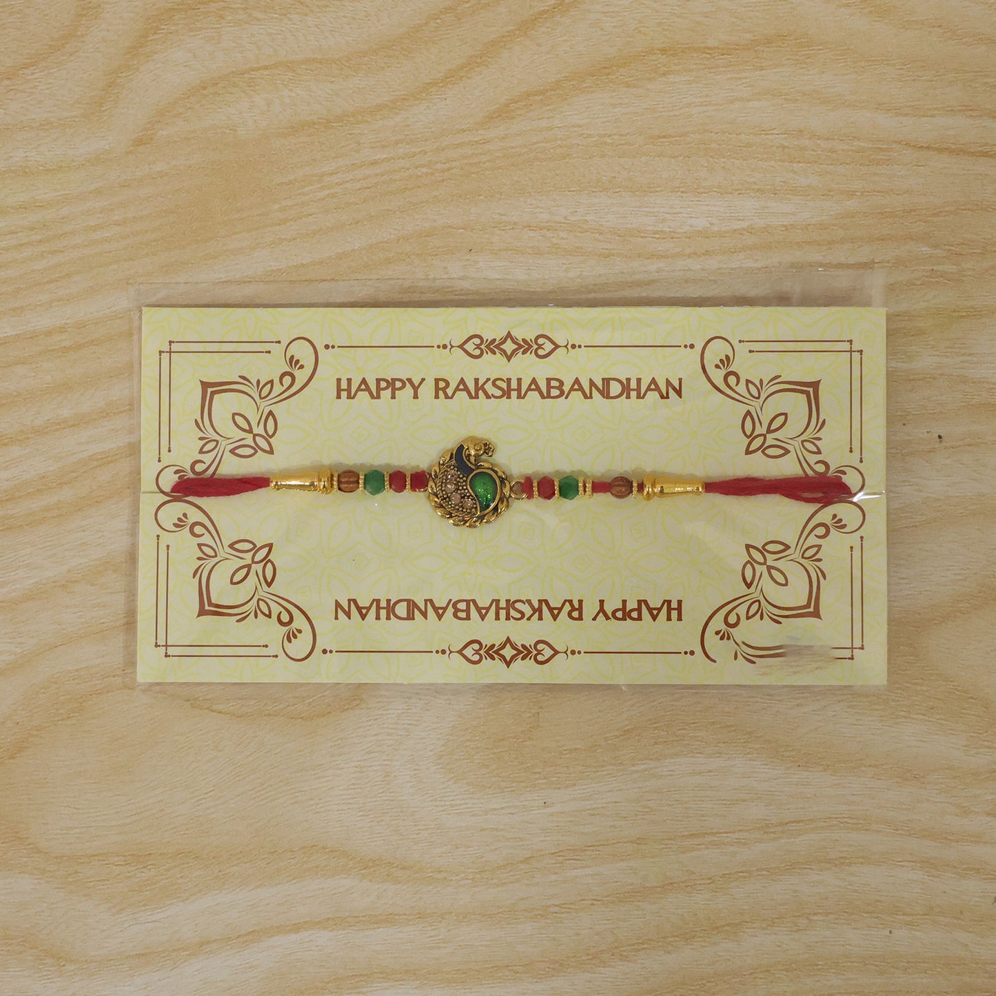 Green Peacock Paisley Rakhi with Golden Detail, Festive Beads and Red Thread