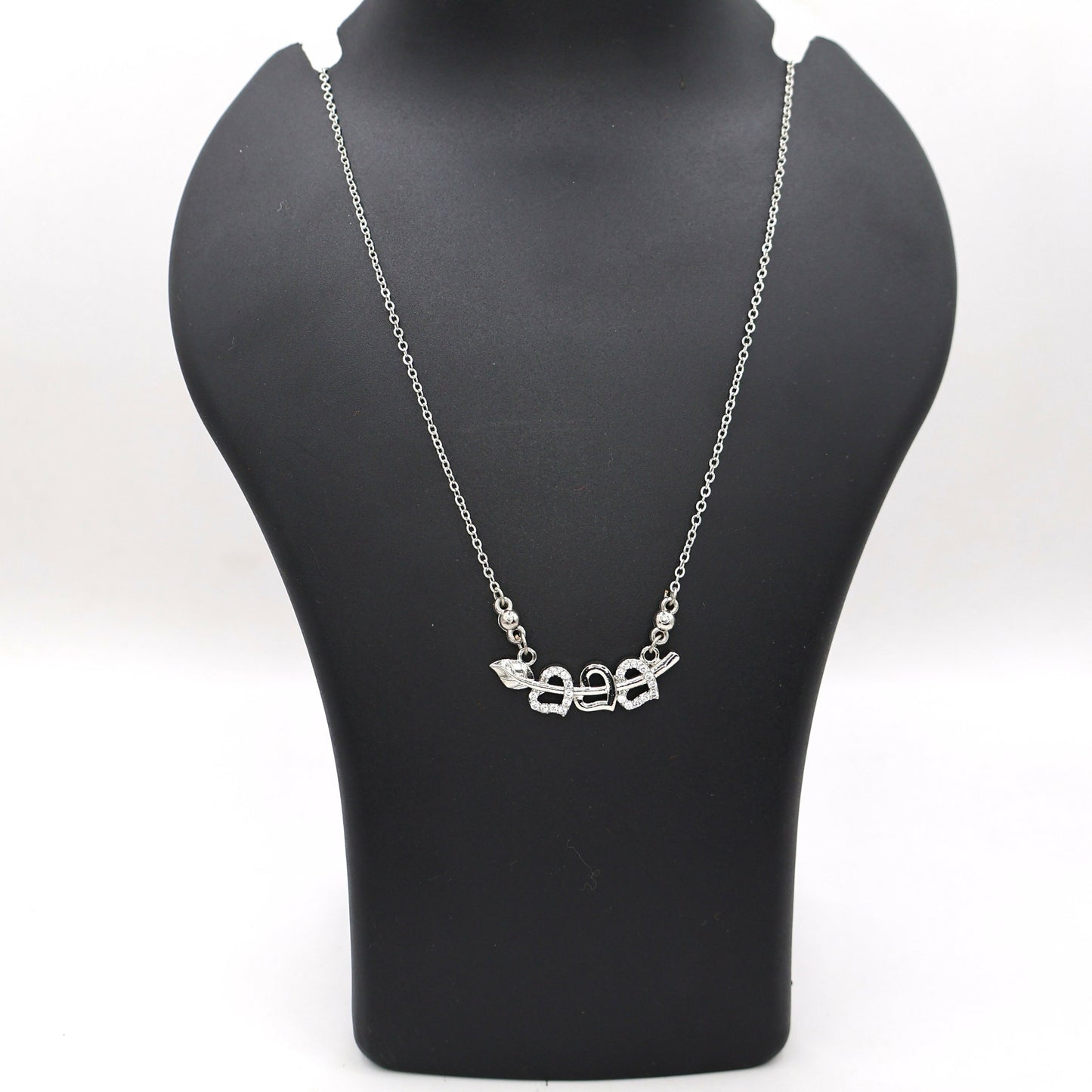 Elegant silver tone Cupid's Arrow necklace featuring two intertwined hearts with CZ stones