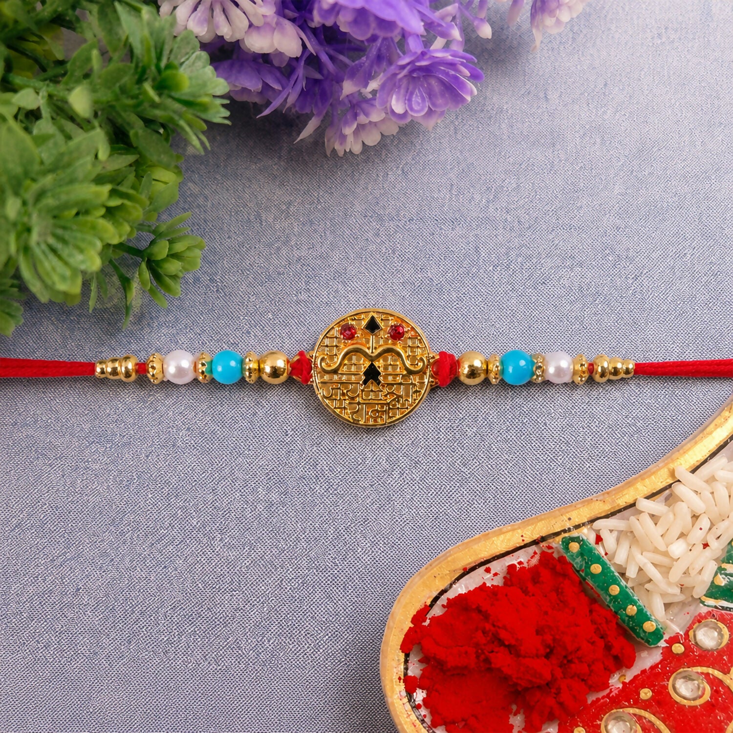 Side view of Golden Shri Ram Rakhi with blue beads