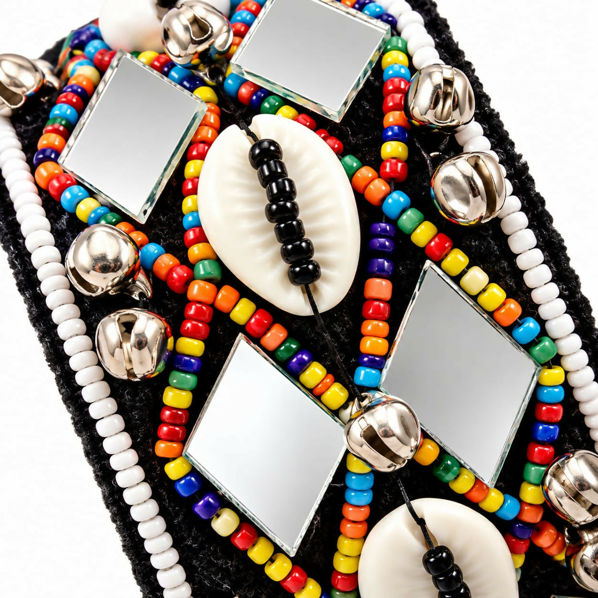 A close-up of a black cuff bracelet with colorful beads, square mirrors, white shells, and silver bells.