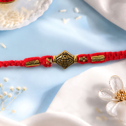 Red Thread Rakhi with an Intricately Detailed Antique Gold Charm