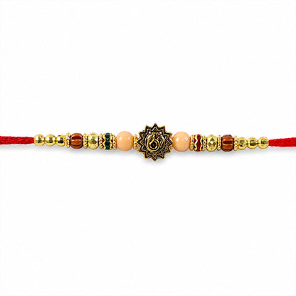 Om Sacred Symbol Golden Devotional Rakhi with Peach Beads and Red Thread