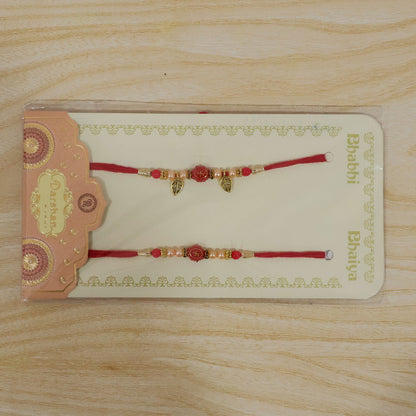 Couple Om Rakhi Set with Red Beads, Golden Leaf Charms and Festive Lumba Pair Design
