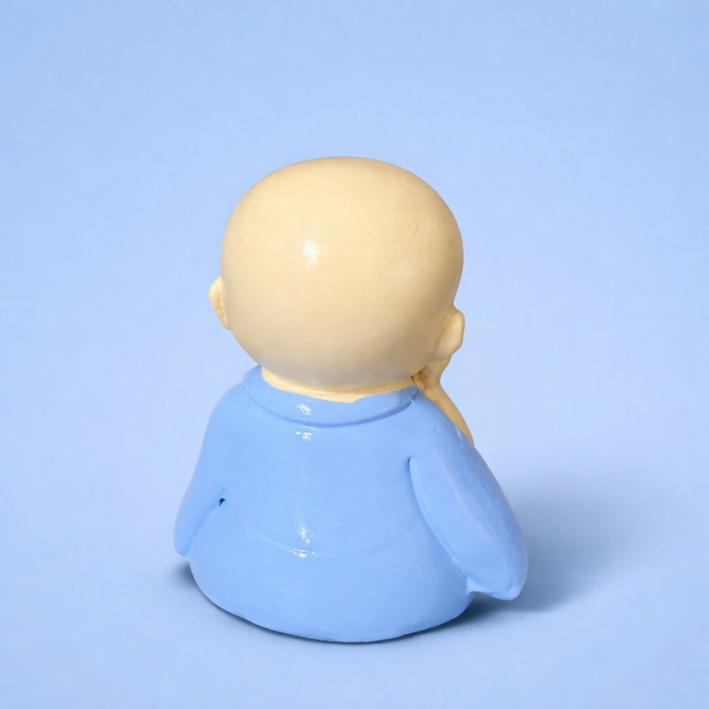 Smiling Monk figurine placed on a wooden shelf