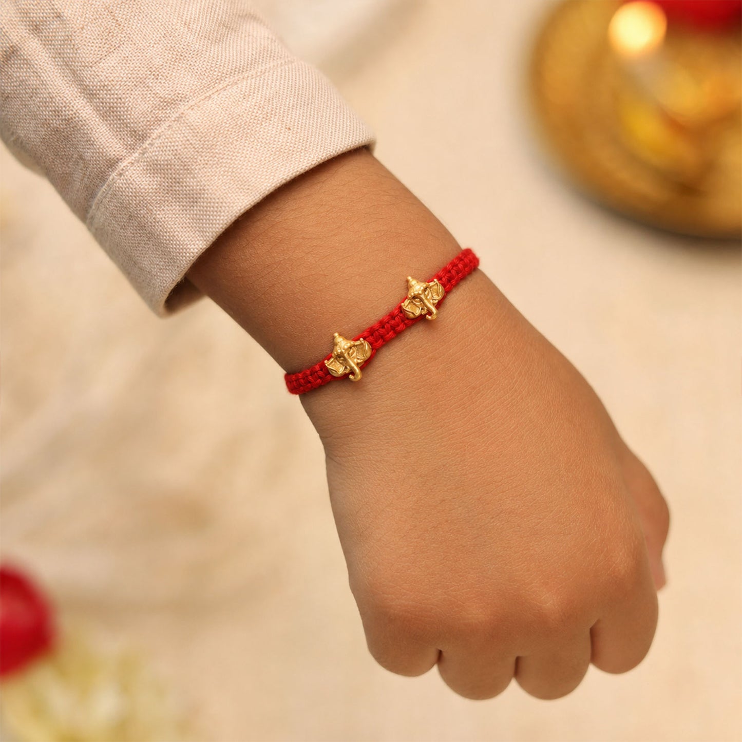 Red Thread Rakhi with Twin Antique Gold Ganesha Shaped Charms