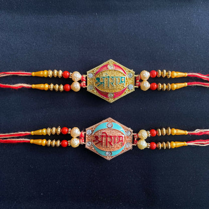 Two designer Rakhis with pearl beads and gold and rose gold finish, one with a green center and one with a blue center, on a