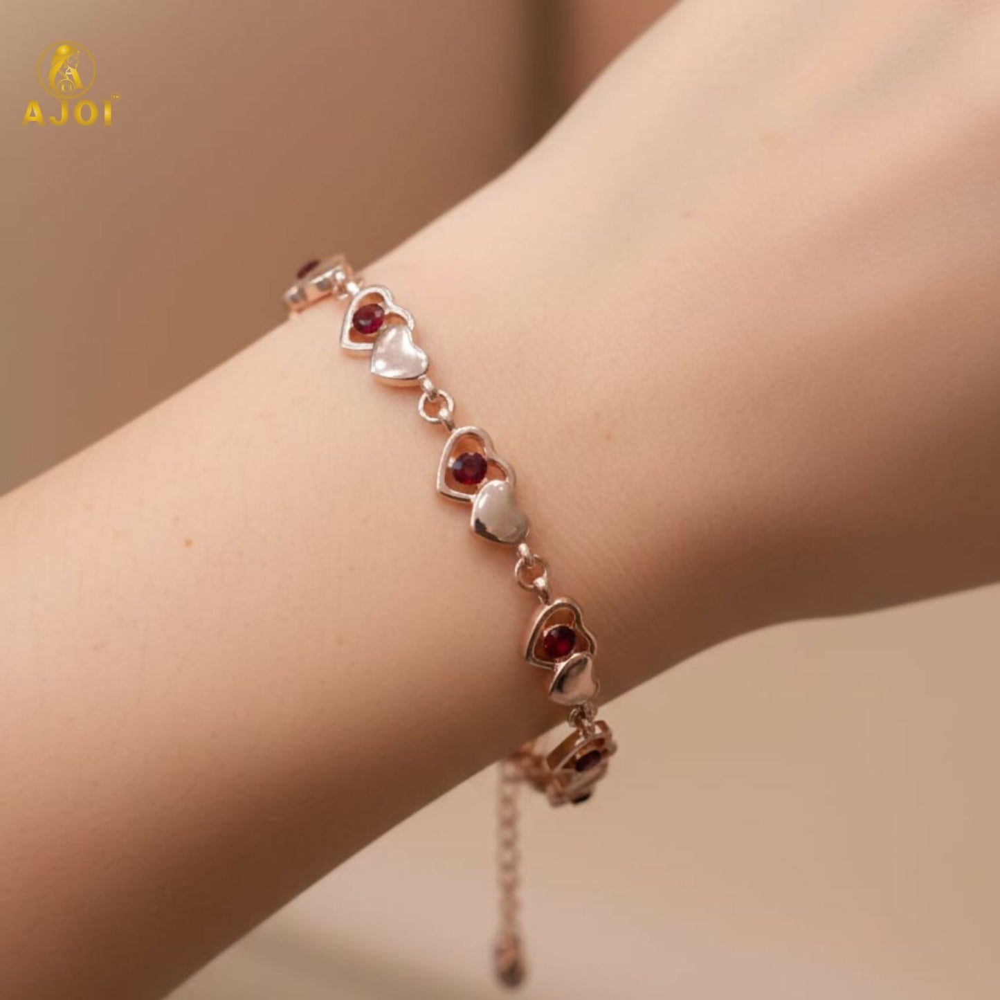 Closeup of gold finish heart crystal bracelet featuring sparkling red crystals