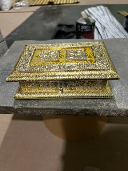 Top view showing yellow-gold patterned interior of metal jewelry box