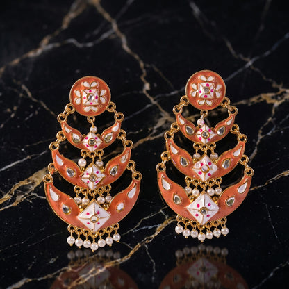 Close-up of detailed meenakari work and pearl accents on peach gold earring