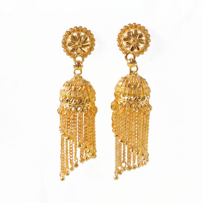 Golden jhumka earrings hanging with tassels visible