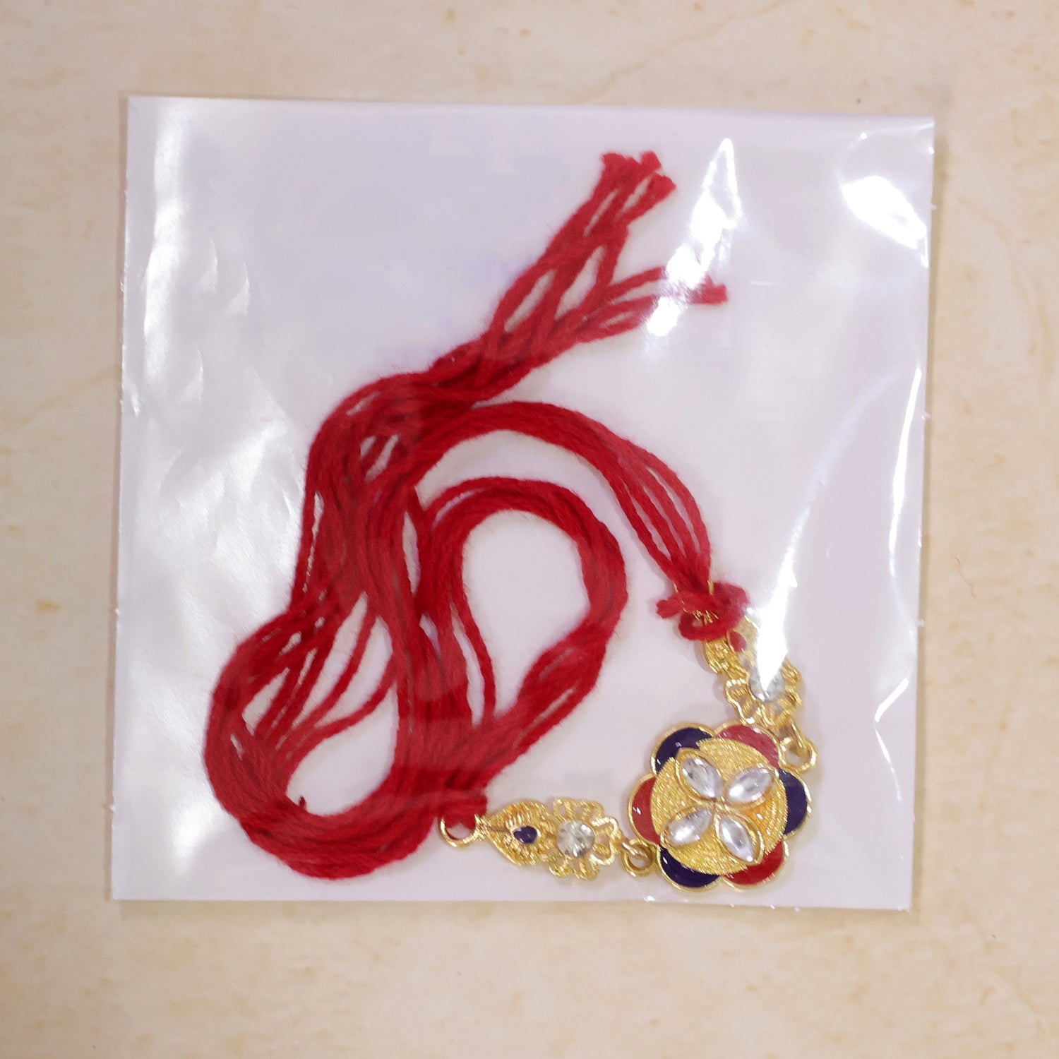 Festive Rakhi showcasing Decorative Rosette, pearl accents and bead line for Gifting