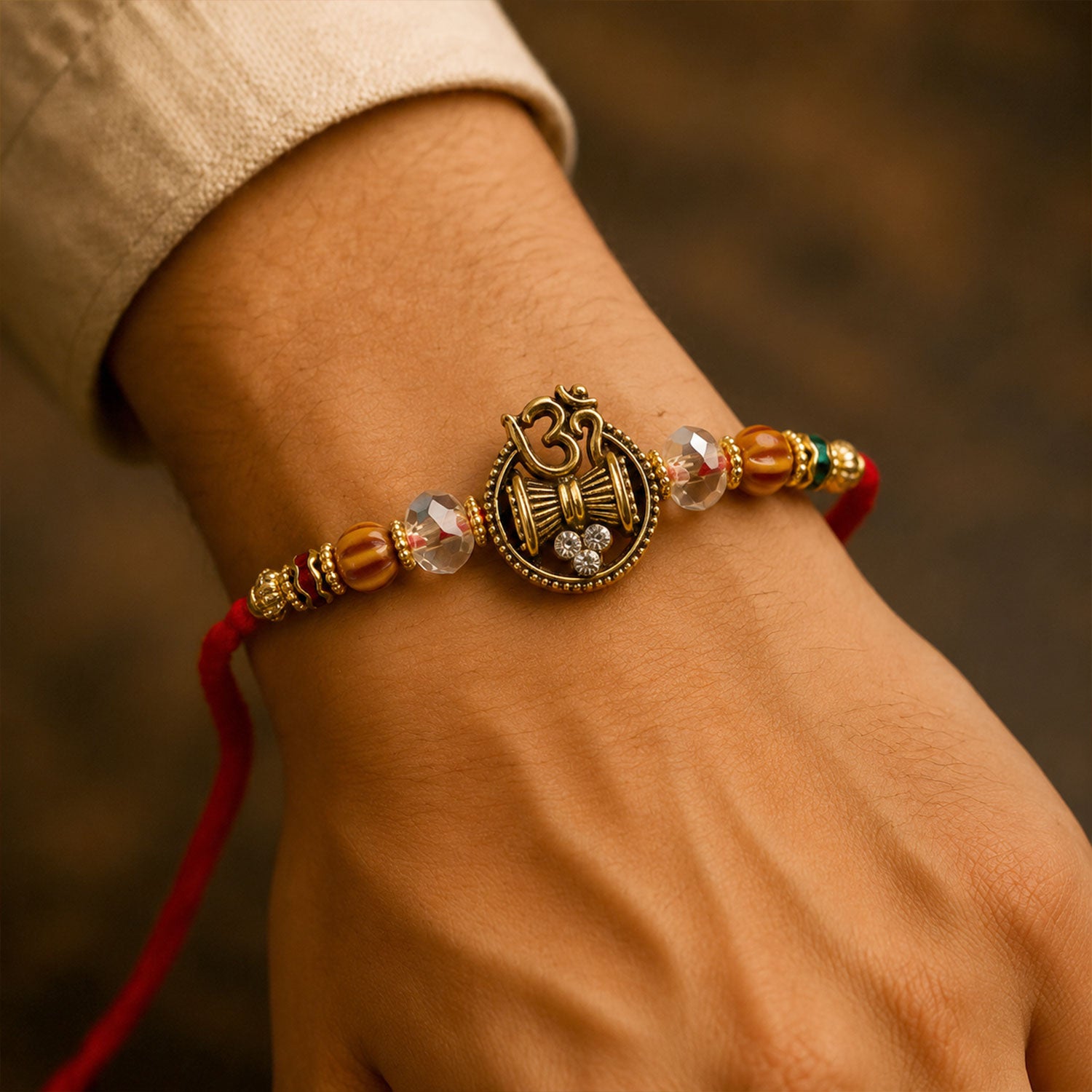 Om Damru Trishul Devotional Rakhi with Sparkling Stones and Brown Beads