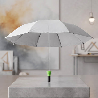 Open grey umbrella with a black shaft and bright green handle standing upright on a concrete block.