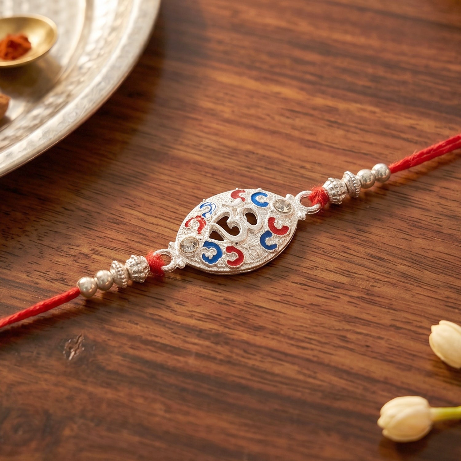 Silver Om Rakhi for Boys with Red Thread and Colorful Accents