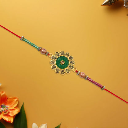 Close-up of floral rakhi showing green centerpiece and colorful beads