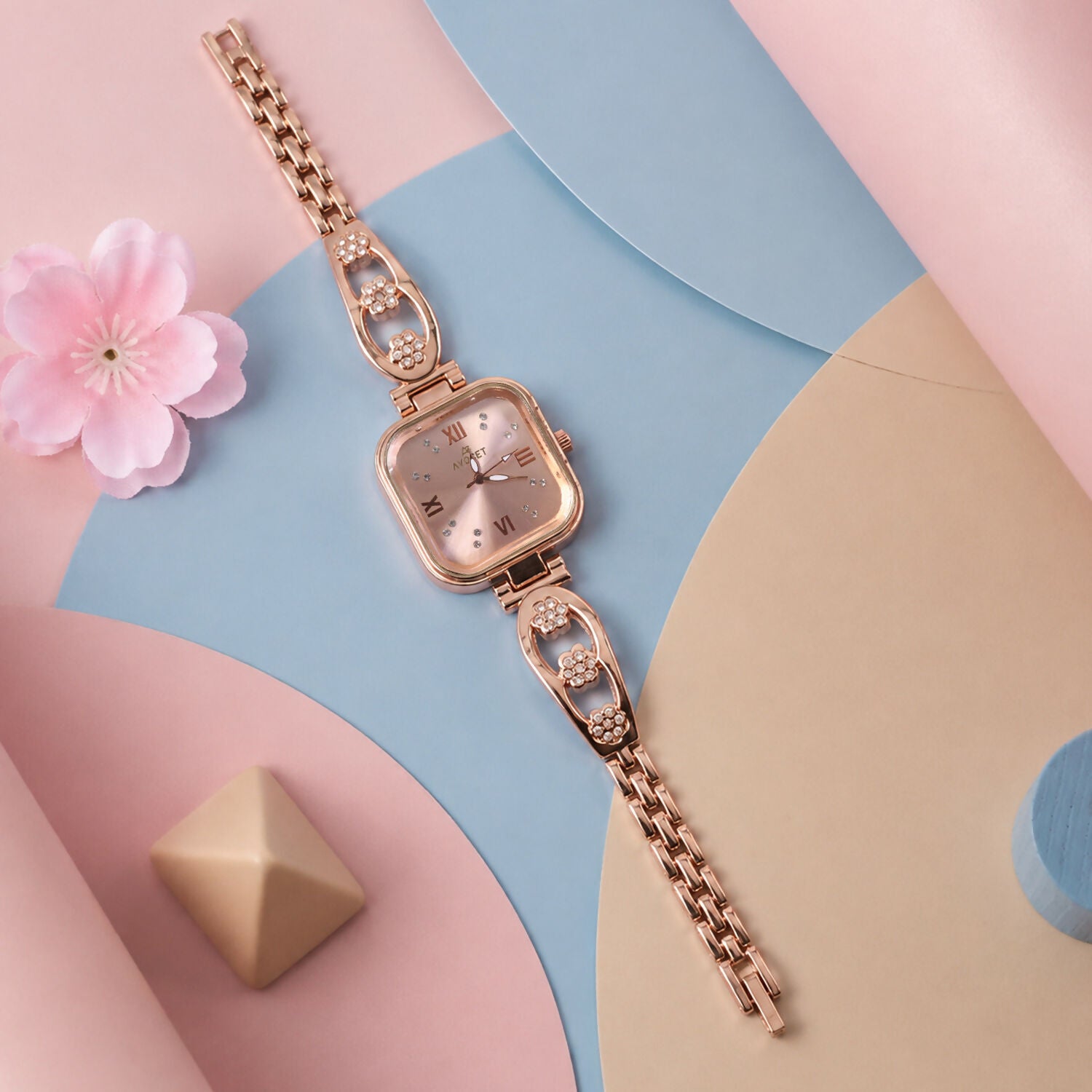 Stylish rose gold analog wrist watch featuring a unique square dial for women.