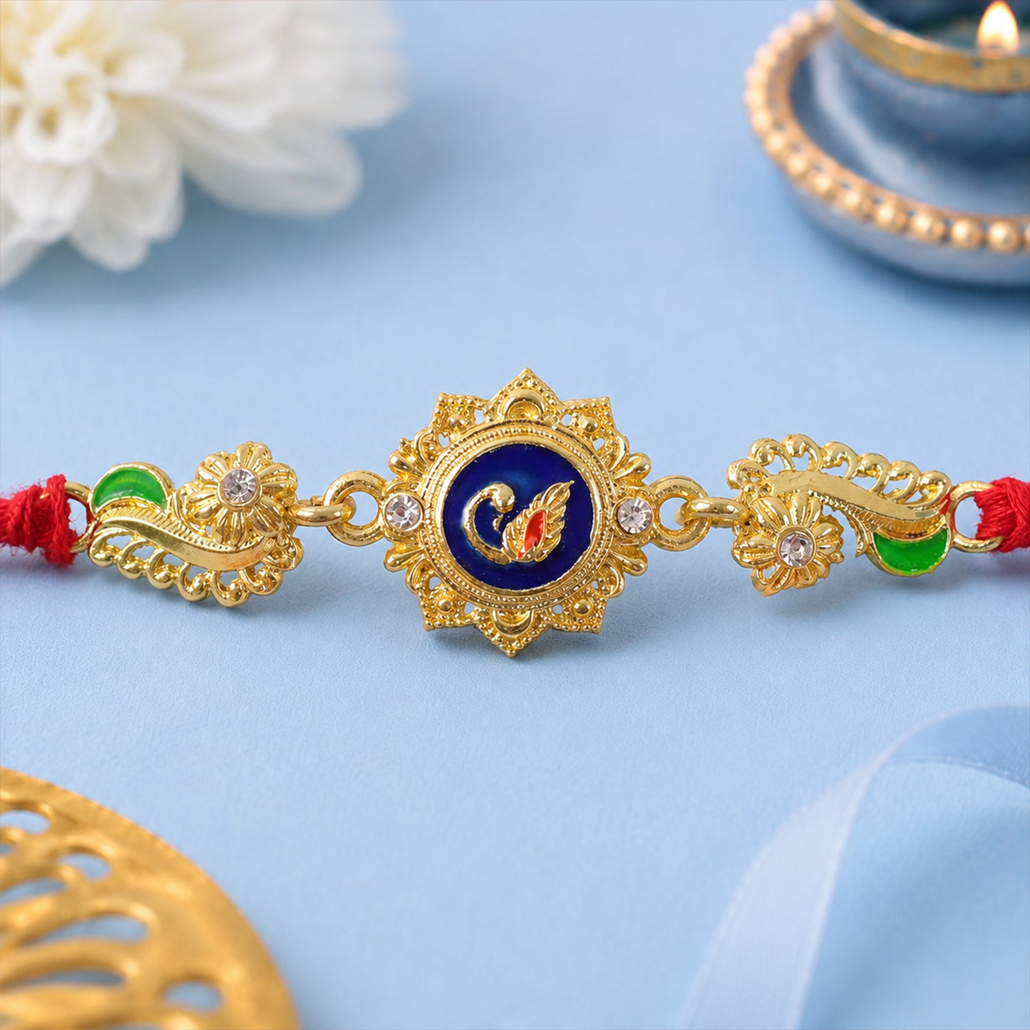 Ornate Rakhi showcasing Blue Oval Medallion, metal trims and chain look for Gift Use