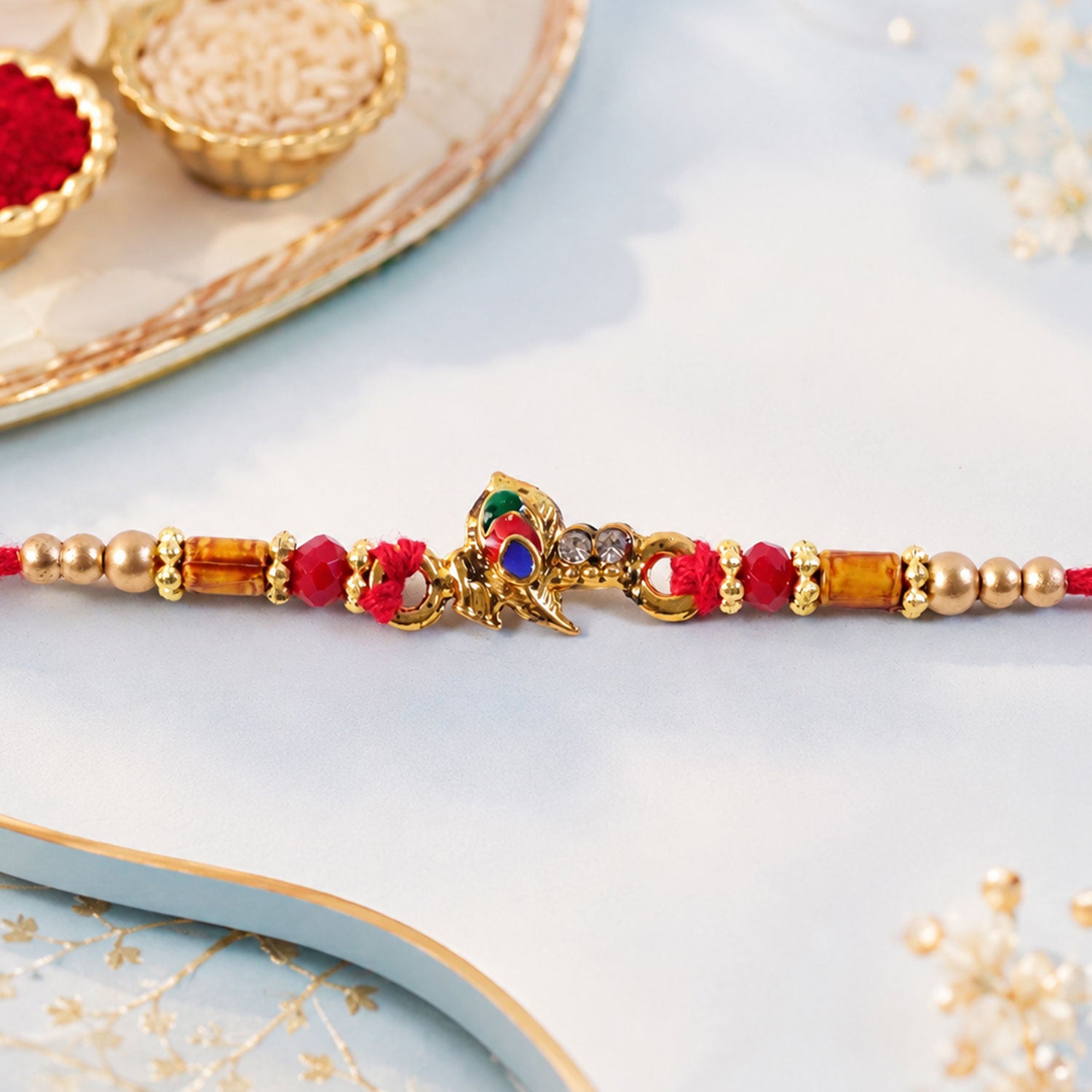 Peacock Floral Crescent Rakhi with Antique Gold Centre, Color Stones and Red Thread
