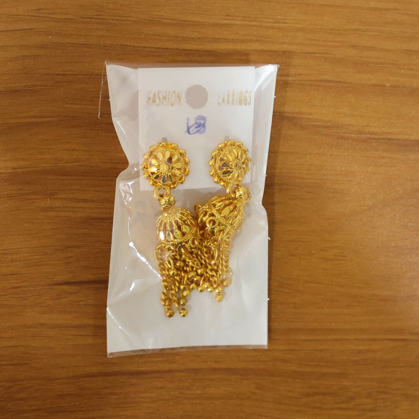 Gold plated long chain jhumka earrings displayed on white background