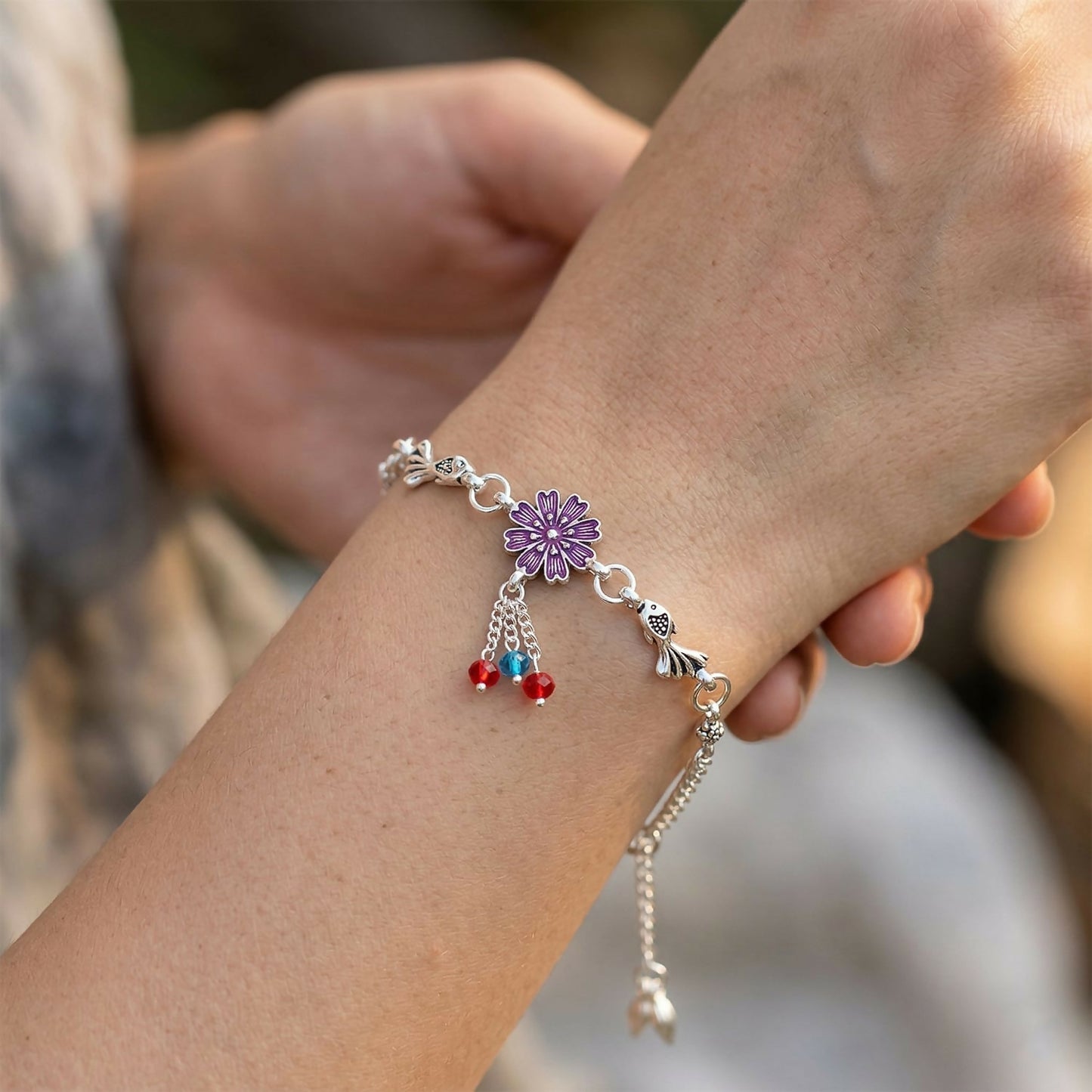 Silver flower charm bracelet showing adjustable chain and clasp