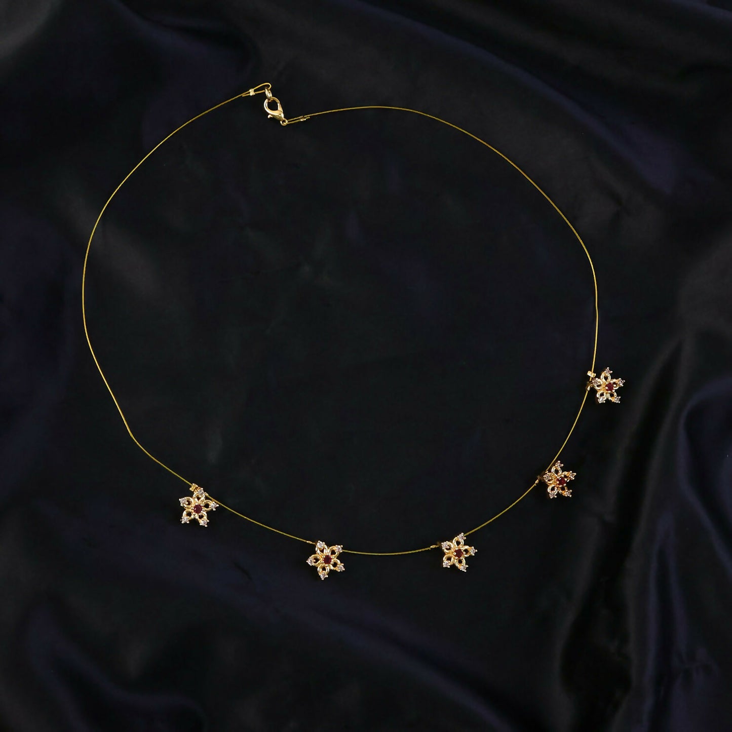 Side view of gold floral star chain necklace