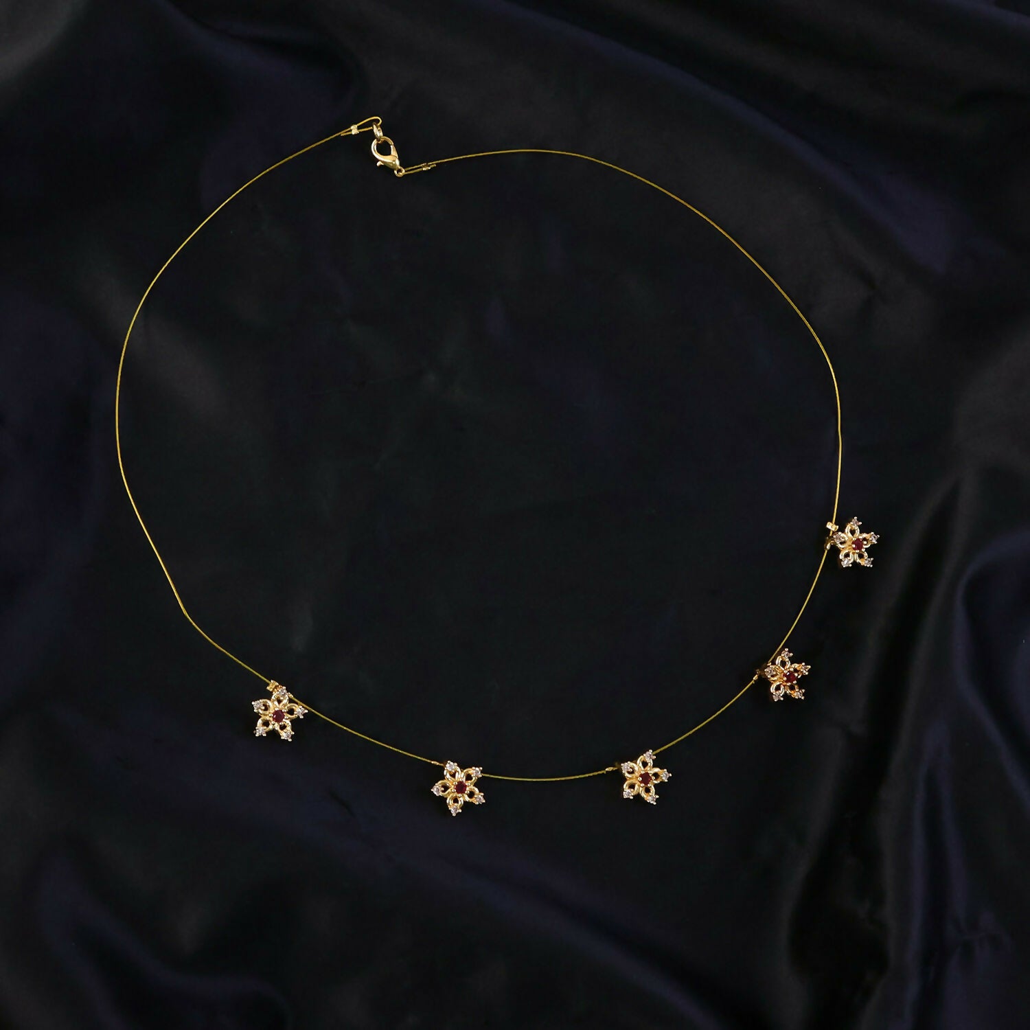 Side view of gold floral star chain necklace
