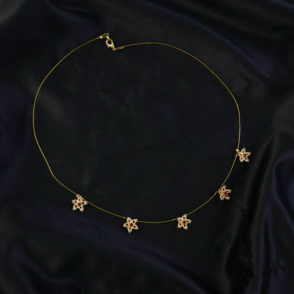 Side view of gold floral star chain necklace