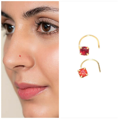 Close-up of gold plated nosepin featuring bright red ruby-style synthetic crystal.