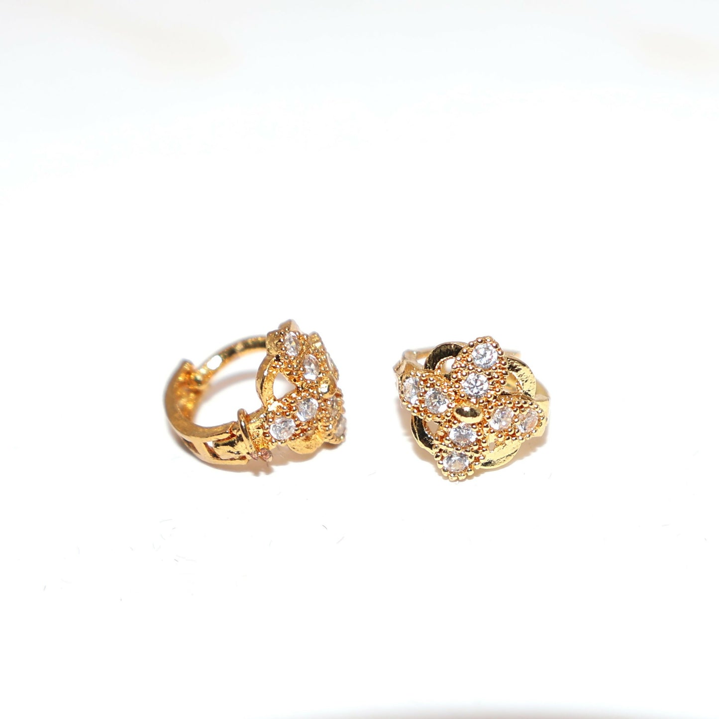 Close-up of sparkling cubic zirconia stones on floral cluster gold plated earrings
