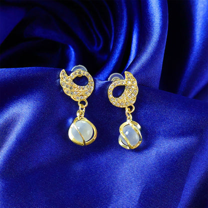 Close-up of designer swan earrings showing crystal details