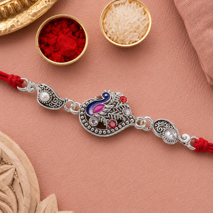 Silver-Toned Peacock Rakhi with Pink-Blue Enamel, Crystal Accents & Red Thread for Brother