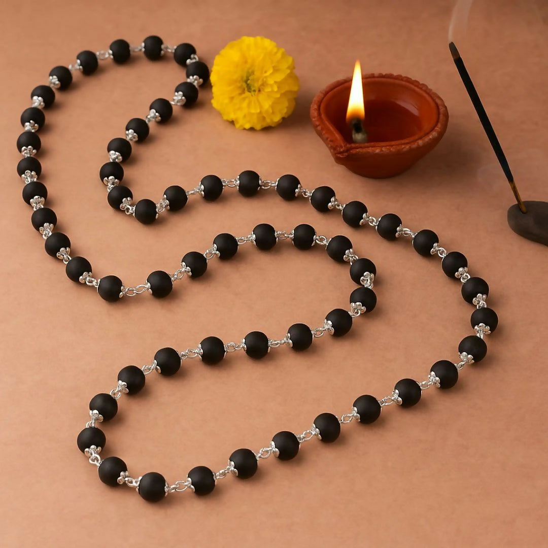 Kalungi Mala with premium matte black 6mm beads and silver flower spacers displayed elegantly