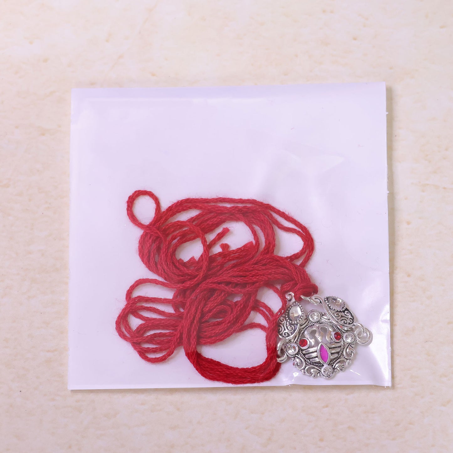 Premium Rakhi showcasing Silver Om Leaf Charm, gold trims and chain look for Gift