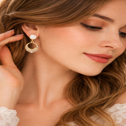 Close-up of gold crystal drop earrings featuring pearl top design