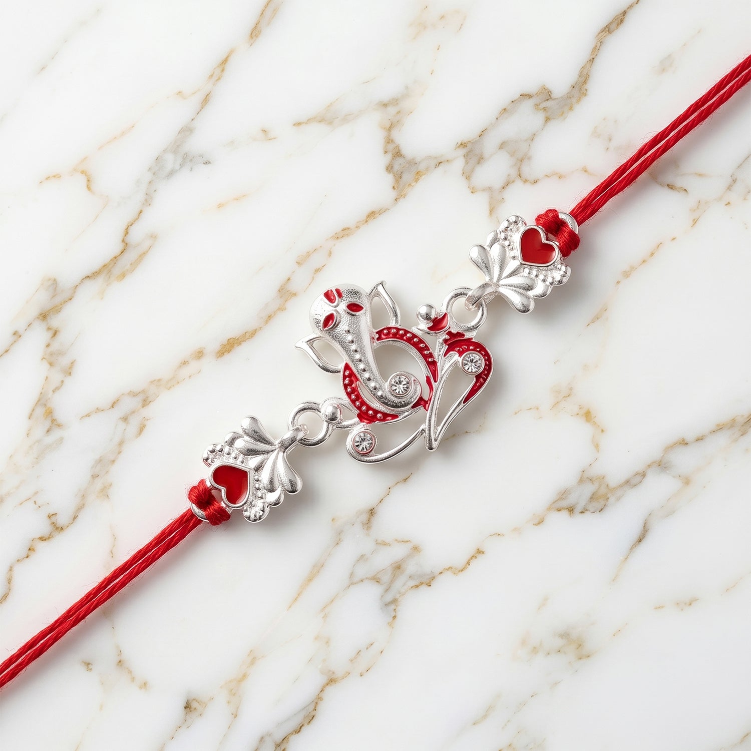 Silver Ganesha Rakhi with Red Stone Hearts and Deep Velvet Look